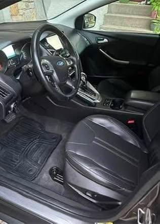 Detailed black car interior with clean leather seats and floor mats